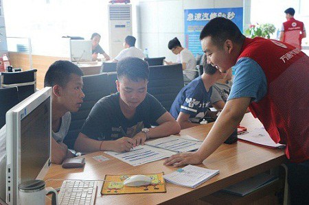 红马甲正在热心指导新生填报入学资料