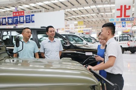 陈陆阳正在为顾客介绍汽车